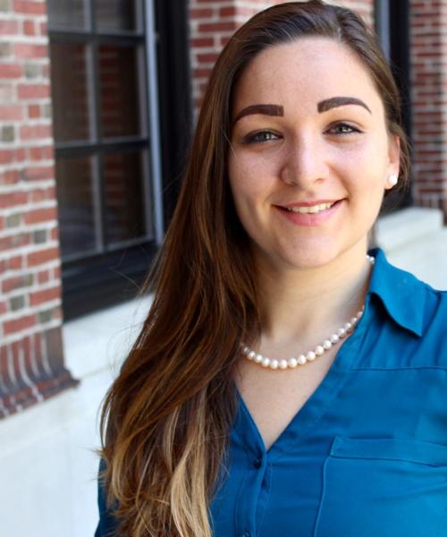 Photo of Courtney Berger Levinson, standing in front of a brick building.